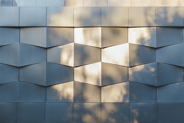 Wall of black metal futuristic new building with flecks  sunlight