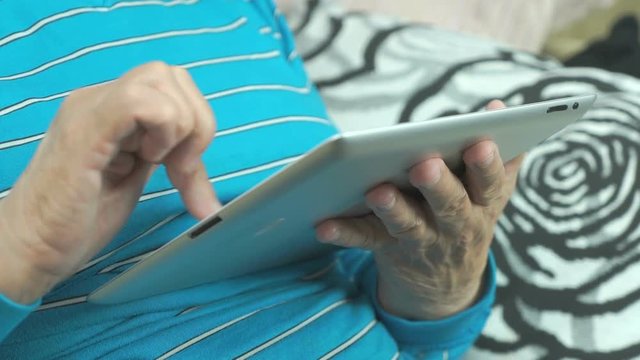 Aged woman using a computer tablet