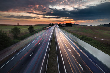 Cars in Motion on Busy Motorway with Colorful Twilight Sky