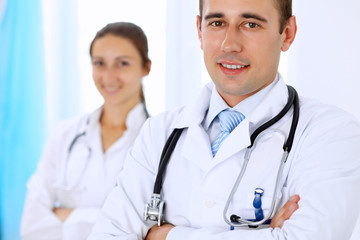 Fototapeta premium Cheerful smiling male doctor with medical staff at the hospital