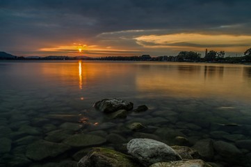Sonnenuntergang am Seeufer Radolfzell mit Steinen im Wasser