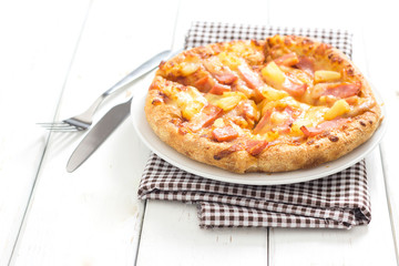 Hawaiian pizza on wooden white table background.