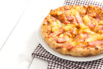 Hawaiian pizza on wooden white table background.