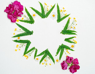 Wreath of chamomile, ranunculus and fern and pink tea roses