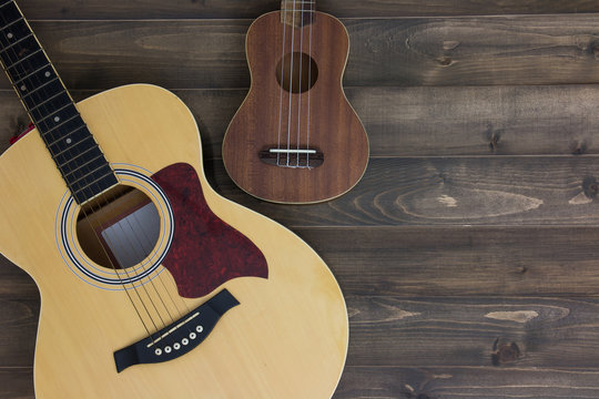 Musical instruments guitar ukulele on old wooden background with copy space. Vintage effect.
