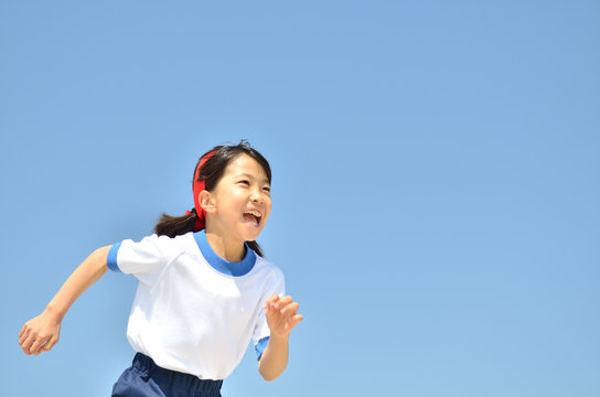 青空で走る女の子(体操服、運動会)