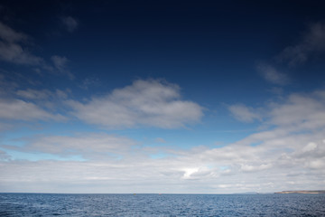 white fluffy clouds down by the sea