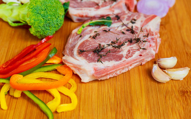 two pieces of raw pork on wooden cutting board ingredients