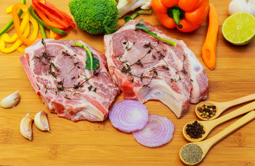 two pieces of raw pork on wooden cutting board ingredients