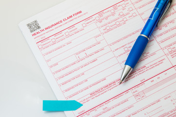 Health insurance claim form with pen on white background. - 121686022