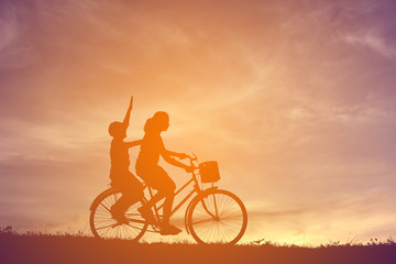 Fototapeta na wymiar Silhouette women and boy playing on sunset