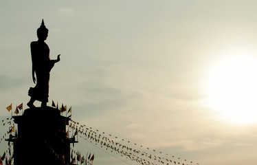 The standing buddha statue silhouette with sunset sky