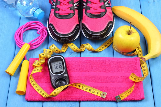 Glucometer, sport shoes, fresh fruits and accessories for fitness on blue boards, copy space for text