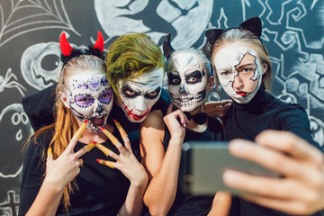 Three girls and a guy going on Halloween, grimace  make selfie