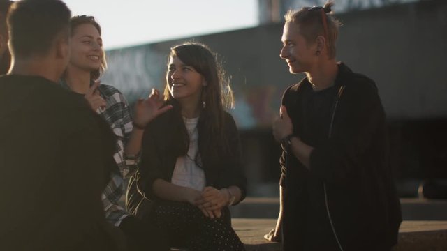 Group of Teenagers Talking and Communicating Outdoors in Bright Summer Day. Shot on RED Cinema Camera in 4K (UHD).
