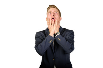 Young businessman dressed in a suit desperate look up isolated on white. Crisis concept.