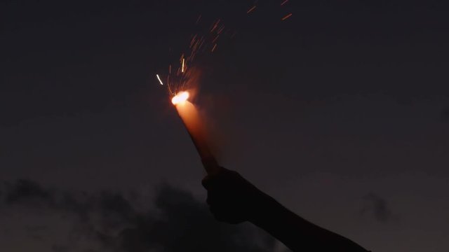 Close-up Shot of Hand Holding Firing Up Red Signal Flare at Evening. Shot on RED Cinema Camera in 4K (UHD).