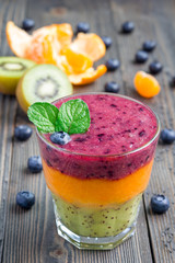 Triple smoothie in glass: kiwi-mint, mandarin-apricot and strawberry-blueberry