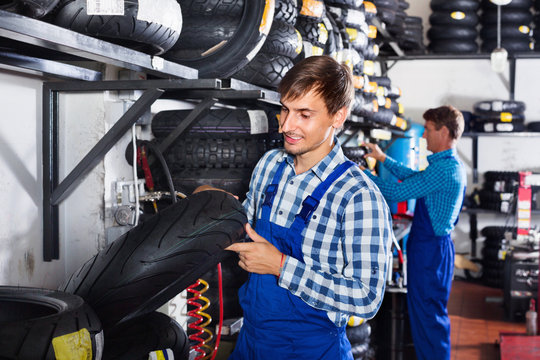 Portrait of mechanic working with bike tires in workshop