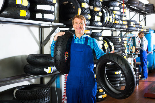 Man standing with new tires for motorbike