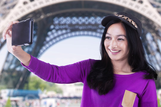 Beautiful girl takes selfie at Eiffel Tower
