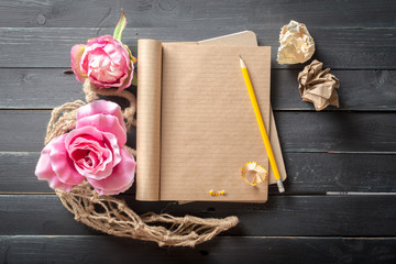 flowers and a notebook on wooden background