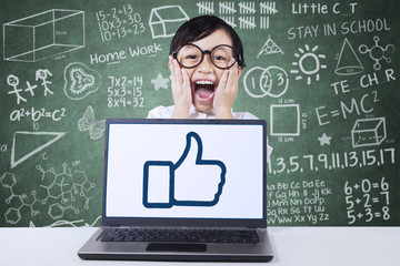 Cute child with OK sign on the laptop screen