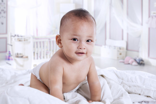 Cute baby crawling in the bedroom