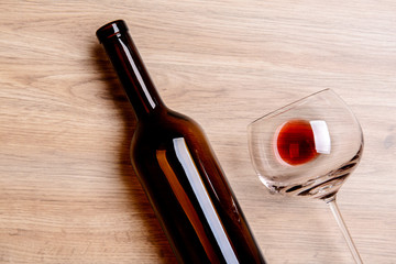 red wine glass with bottle on wooden ground