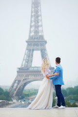 Obraz premium Just married couple near the Eiffel tower in Paris