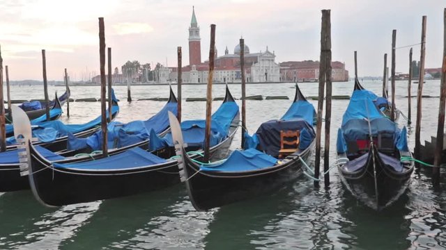 Gondolas moored by Saint Mark square in sunrise. San Giorgio di Maggiore church is in the background (Venice, Italy)