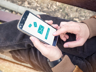 Businessman sending email message via modern smartphone outdoor