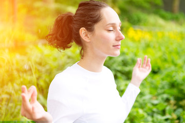 Young attractive woman practising yoga in a park