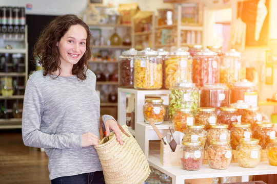 Young attractive woman shooping looses spices at the grocery
