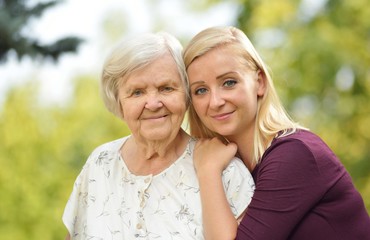 Grandmother and granddaughter. Young woman carefully takes care
