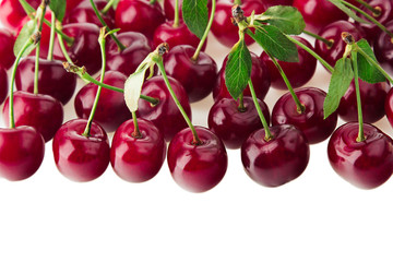 Bunches of ripe cherries with leaves on a white background. Isolated. Decorative fruit border. Food background. Copy space.