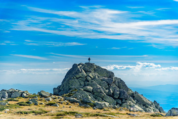 Lonely man on top of a rock at Vitosha, Sofia, Bulgaria against clear blue sky
