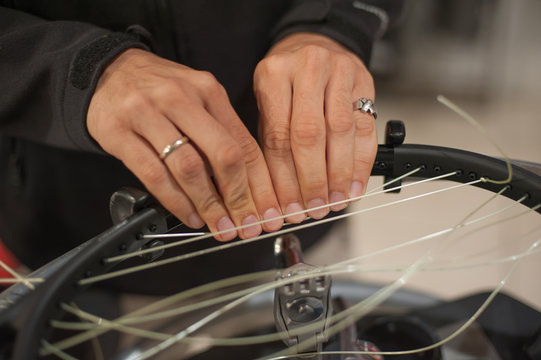 Stringing Machine. Close up of tennis stringer hands doing racket stringing in his workshop