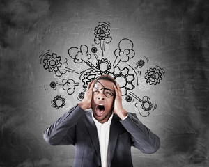 Stressed African businessman near blackboard