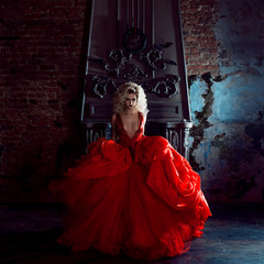 Fashion photo of young magnificent woman. Running towards camera. Seductive blonde in red dress...