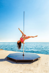 Female pole dancer against the sea and sky © Andriy Petrenko