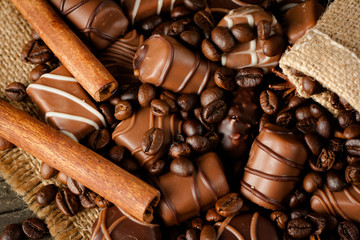 Assortment of white, dark, and milk chocolate. Chocolate with cream, nuts, almonds, hazelnuts and cinnamon with coffee beans. Sweet food and no diet concept.