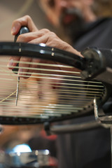 Stringing Machine. Detail of tennis stringer hands while holding awl and doing racket stringing