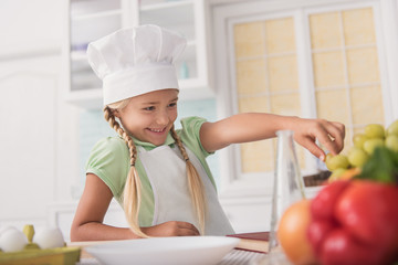 Pretty kid cook eating healthy food