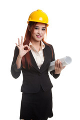 Asian engineer woman with blueprints show OK hand sign.