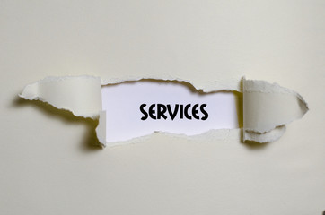 The word services appearing behind torn paper