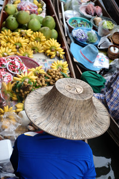 Kobieta na targu wodnym w Damnoen Saduak sprzedaje owoce. Tajlandia.
