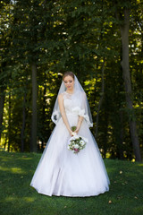 Beautiful bridal bouquet in hands of young bride dressed in white wedding dress.