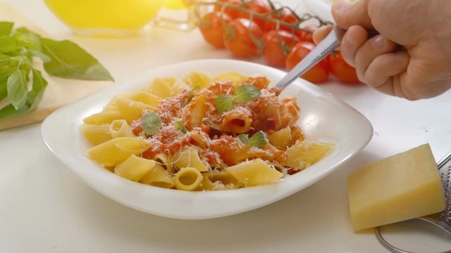Hot Pasta with tomato Sauce, Parmesan Cheese and Basil on a Spoon