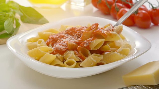 Hot Pasta with tomato Sauce, Parmesan Cheese and Basil on a Spoon